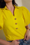 Detail view of cropped blouse with gold button design